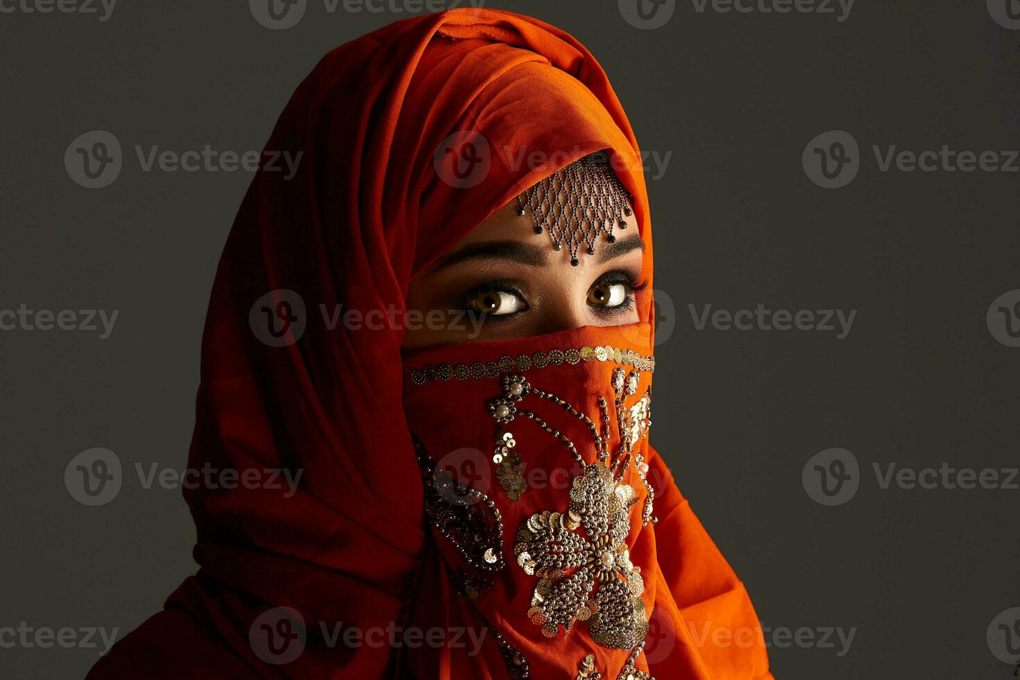 studio coup de une Jeune charmant femme portant le terre cuite hijab décoré avec paillettes et bijoux. arabe style. photo