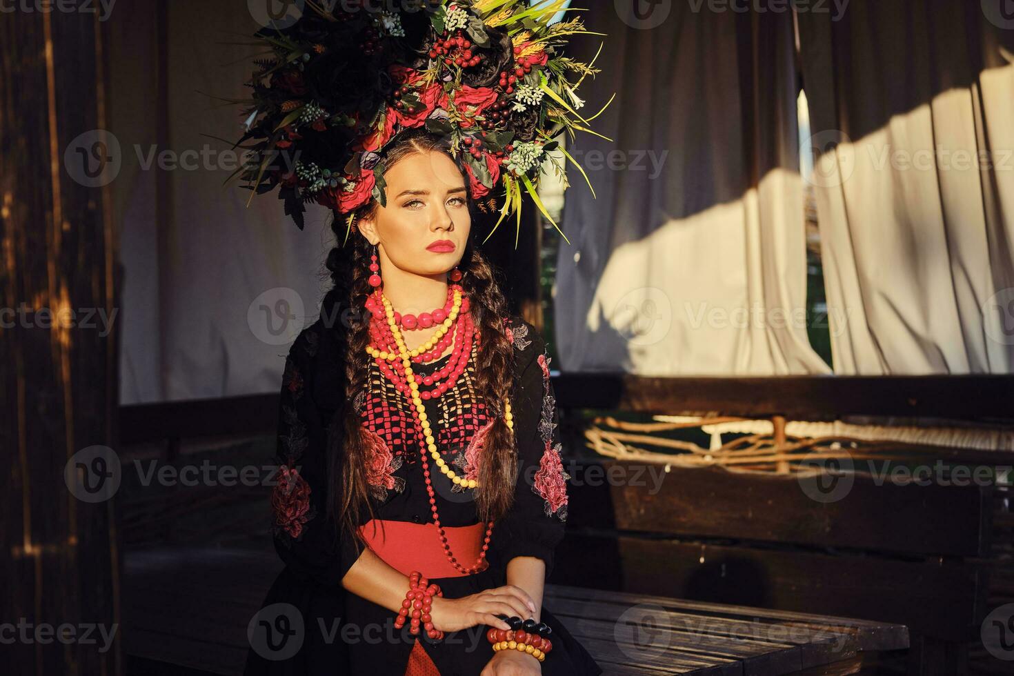 brunette fille dans une blanc ukrainien authentique nationale costume et une couronne de fleurs est posant contre une terrasse. fermer. photo