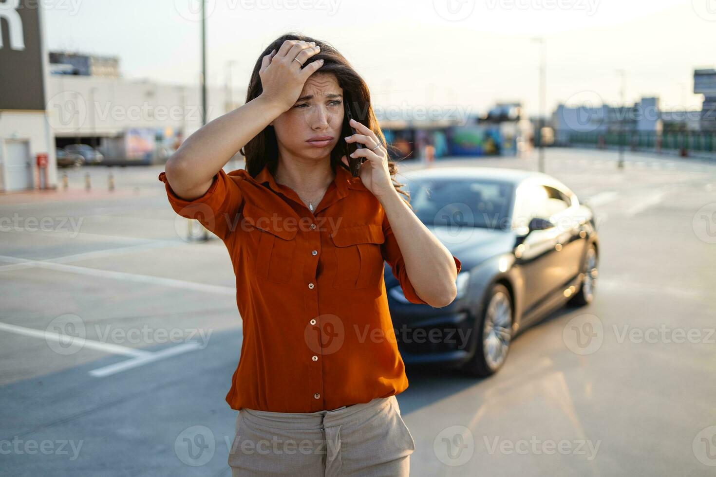 je suis ayant voiture problèmes. stressé femme avec parlant sur le téléphone avec une bord de la route assistance service. cassé vers le bas voiture sur le côté de le route, appel le Assurance entreprise pour assistance photo