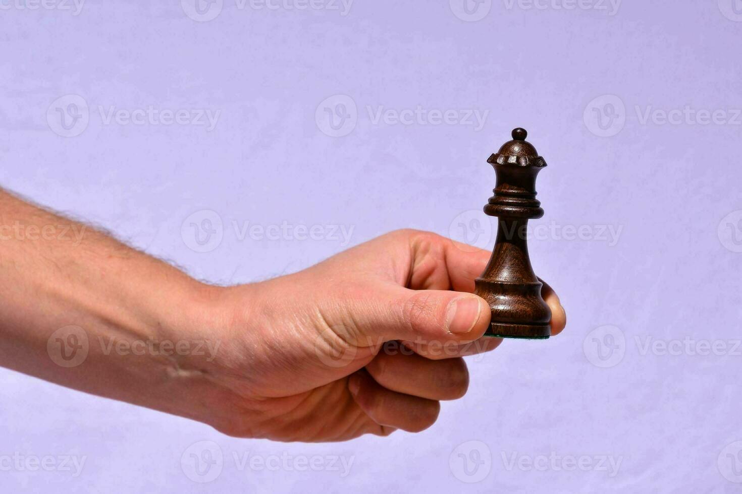 une main en portant une échecs pièce sur une blanc Contexte photo