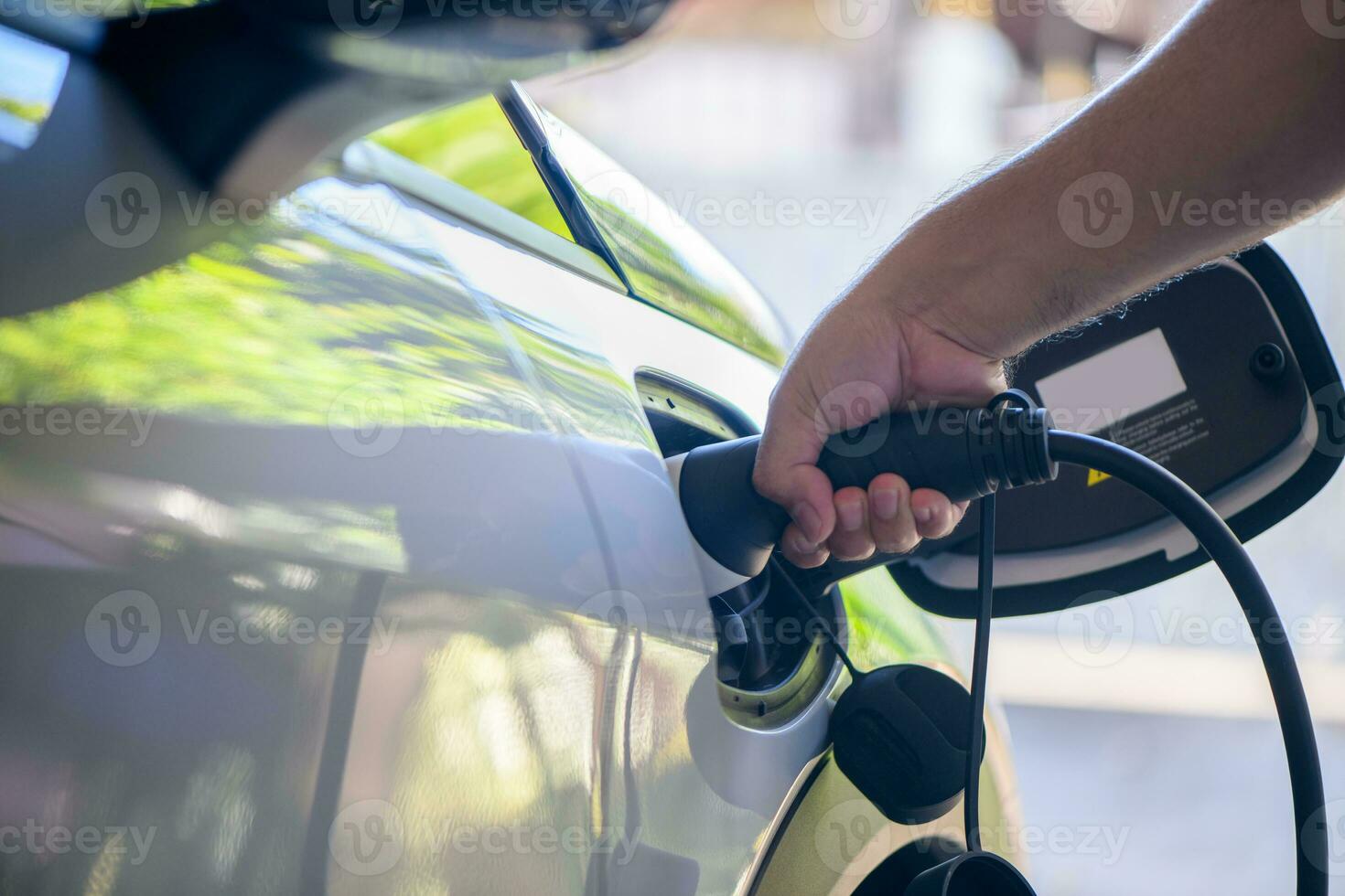 homme mettre bouchons mise en charge câble électrique véhicule. chauffeur supprime chargeur de le sien électrique véhicule. photo