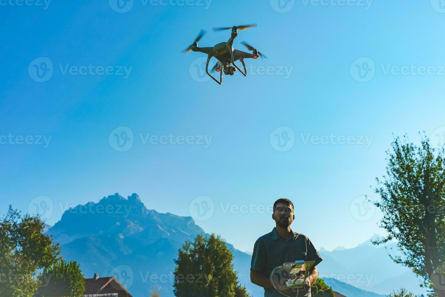 Jeune homme en volant drone sur incroyable Montagne paysage. homme en fonctionnement une drone avec éloigné contrôle prise aérien Photos et vidéos.