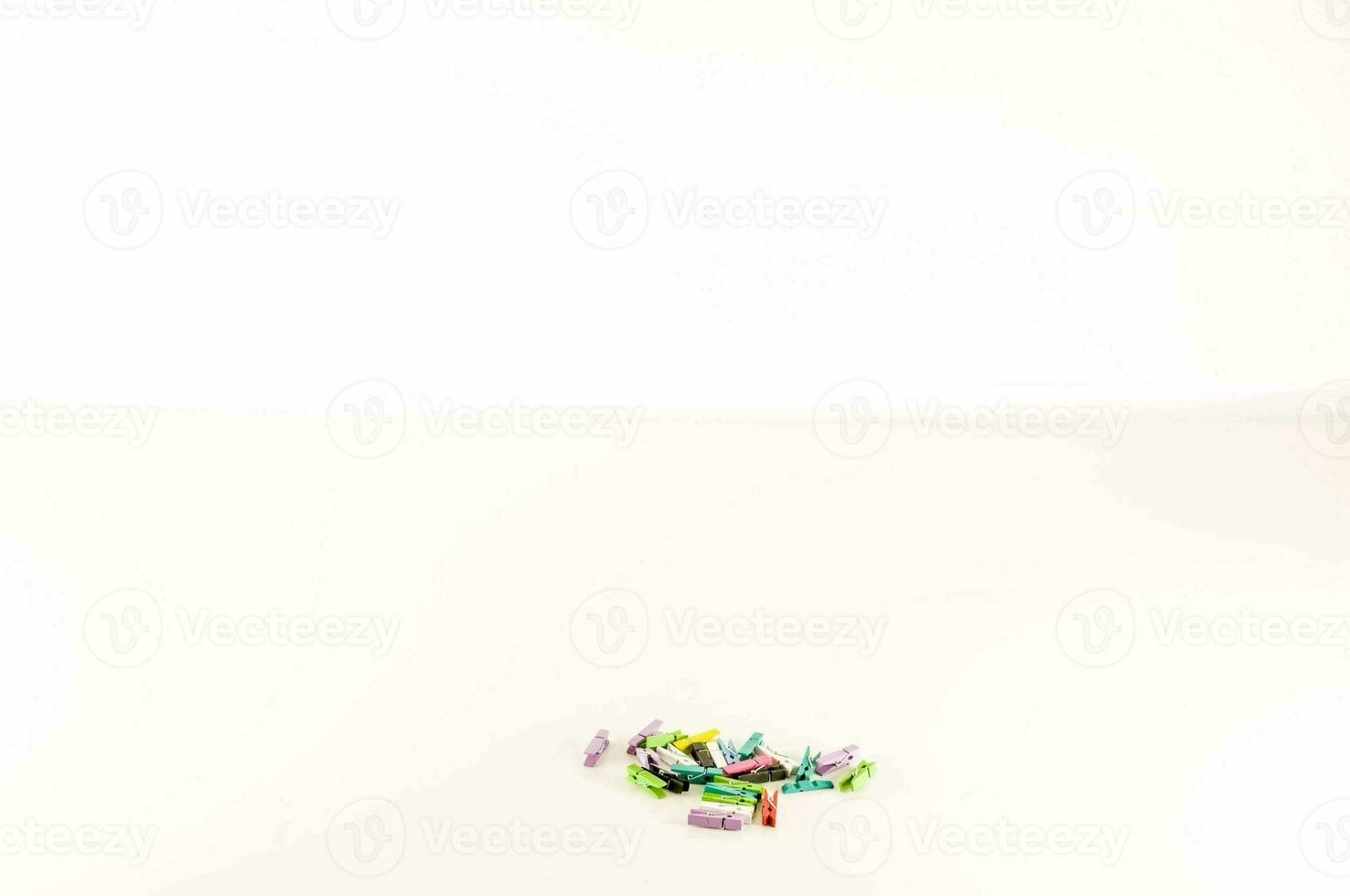 une pile de coloré pinces à linge sur une blanc surface photo