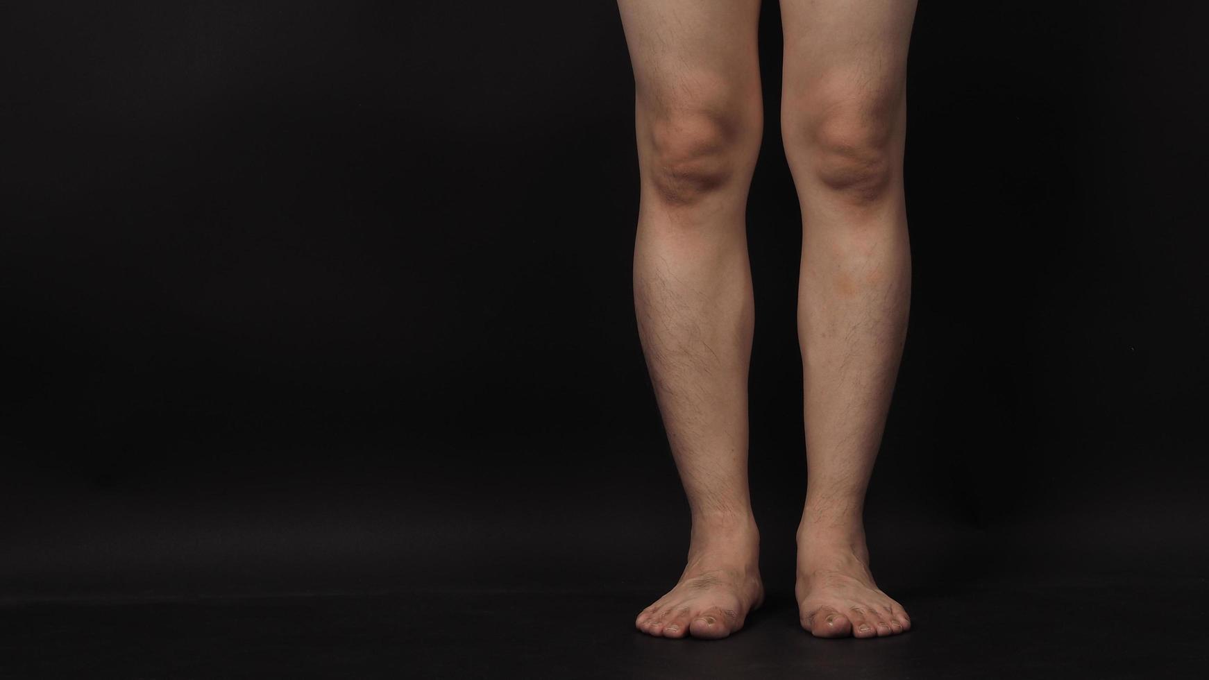 les jambes des hommes asiatiques et les pieds nus sont isolés sur fond noir photo