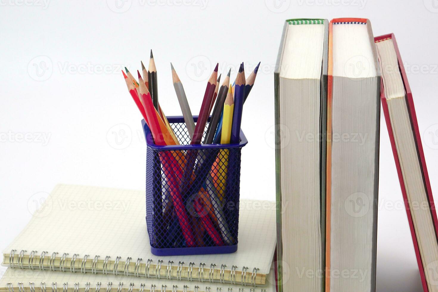 crayon ou coloré des crayons dans boîte pose sur une empiler de livres, blanc Contexte. connaissance et éducation concept. photo