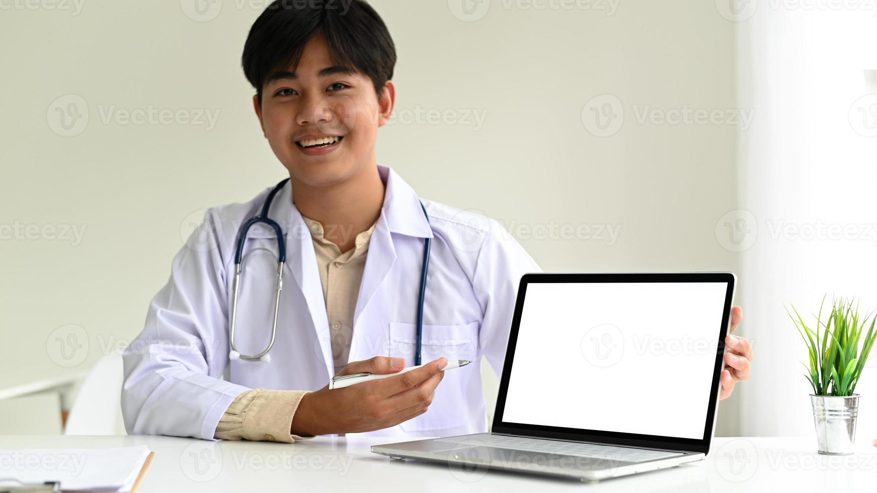 un médecin spécialiste en blouse de laboratoire avec un stéthoscope utilise un ordinateur portable pour guider les patients, le médecin utilise un ordinateur portable pour recommander des traitements en ligne. photo