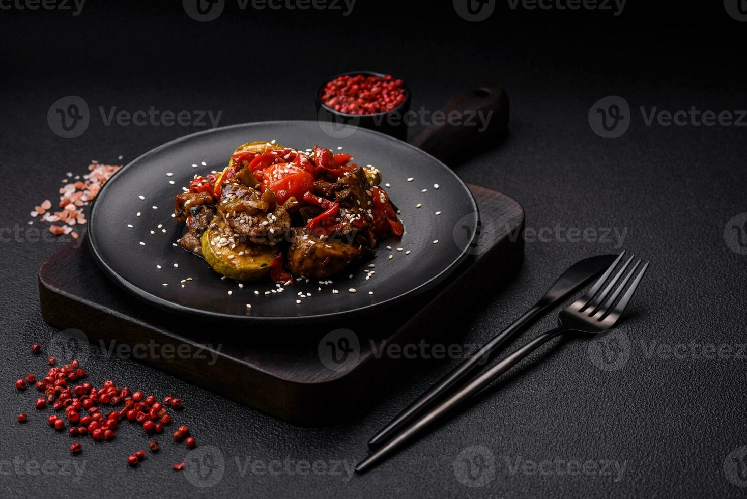 chaud salade avec veau, tomates, poivrons, courgette, sésame, sel, épices et herbes photo