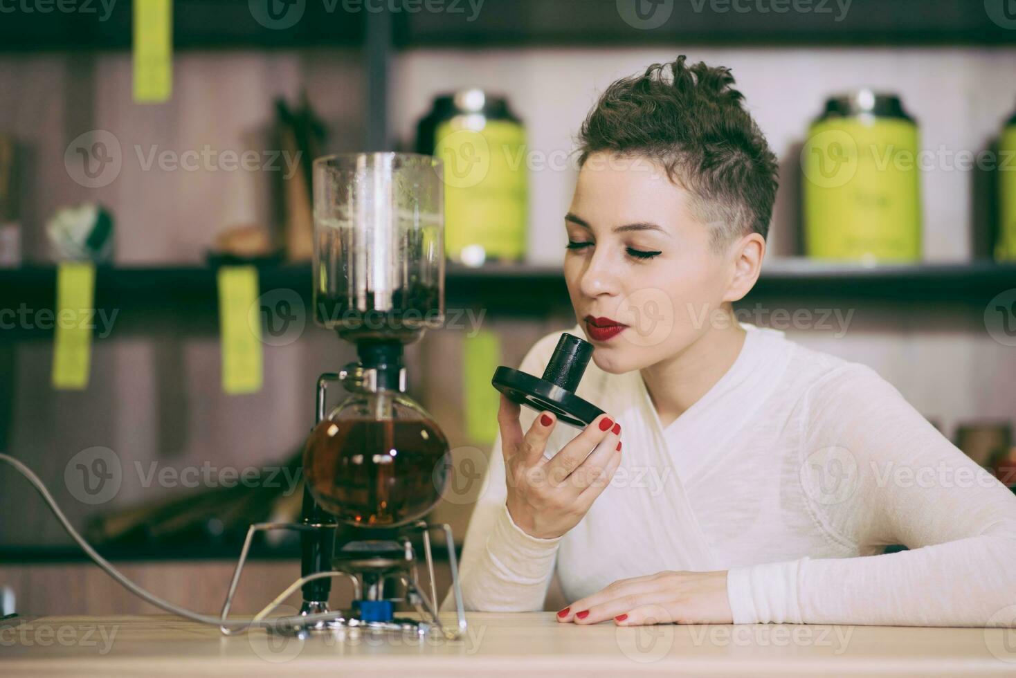 le fille est fabrication thé dans une café photo