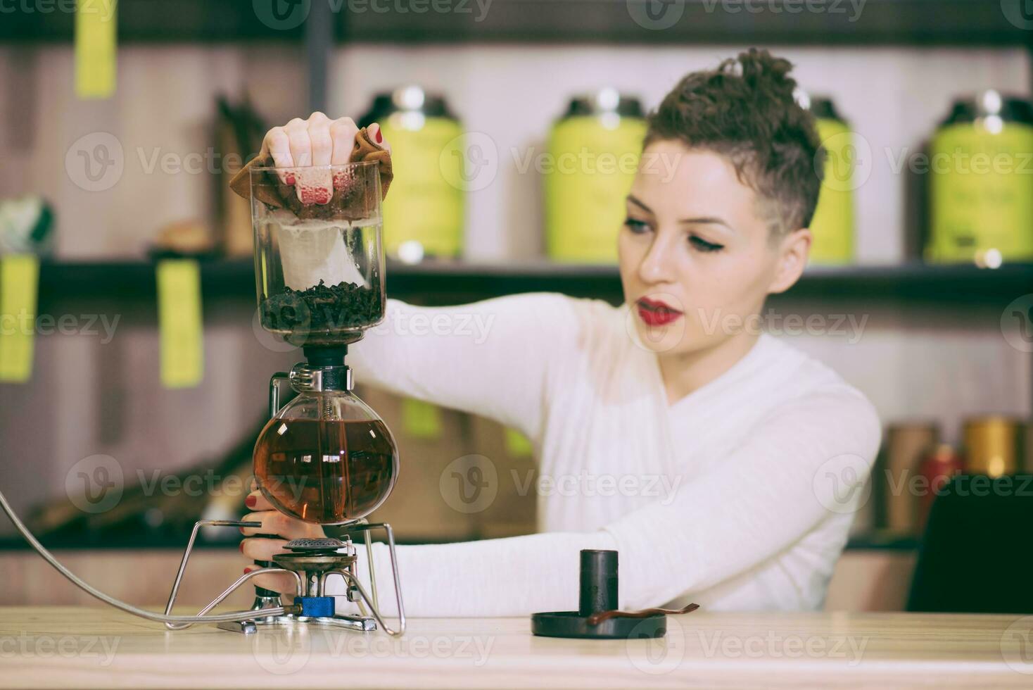 le fille est fabrication thé dans une café photo