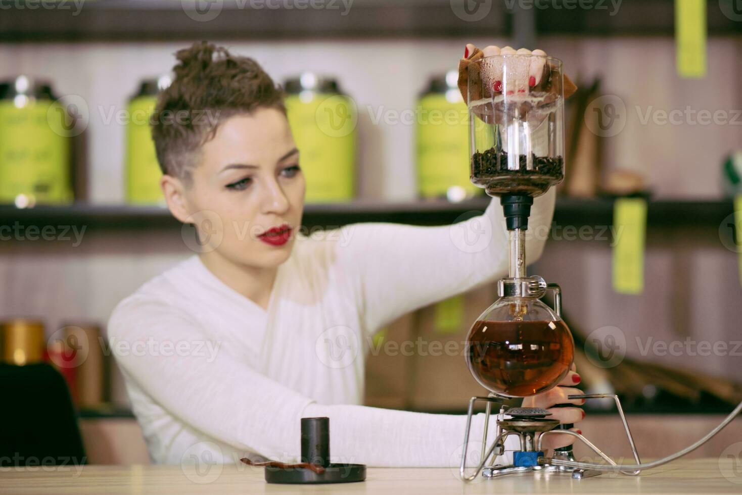 le fille est fabrication thé dans une café photo