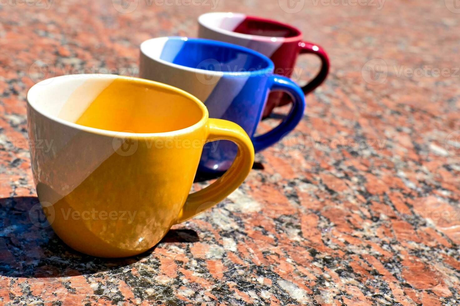 temps de la cérémonie pour thé et café.coloré tasses sur rouge marbre surface photo