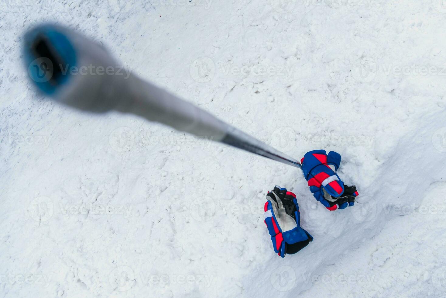 le gants et le hockey bâton allonger sur le neige photo