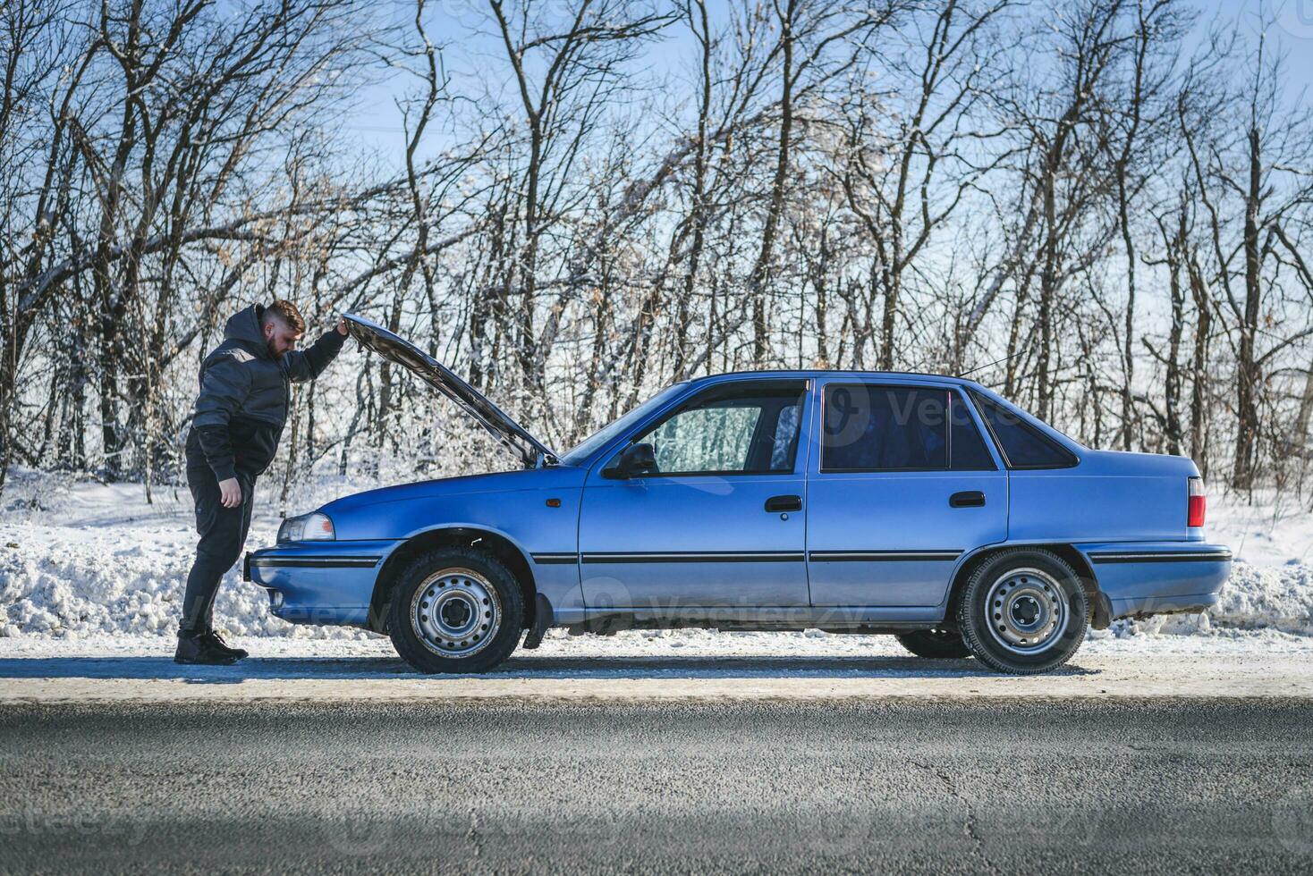 homme réparer une voiture permanent à le capuche photo