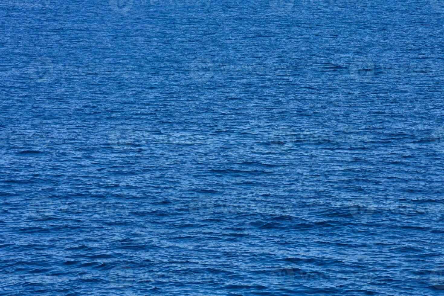 le océan est bleu et calme avec une peu bateaux photo