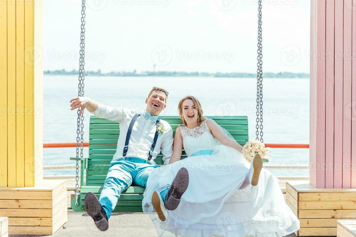 le la mariée et jeune marié balade sur une balançoire photo