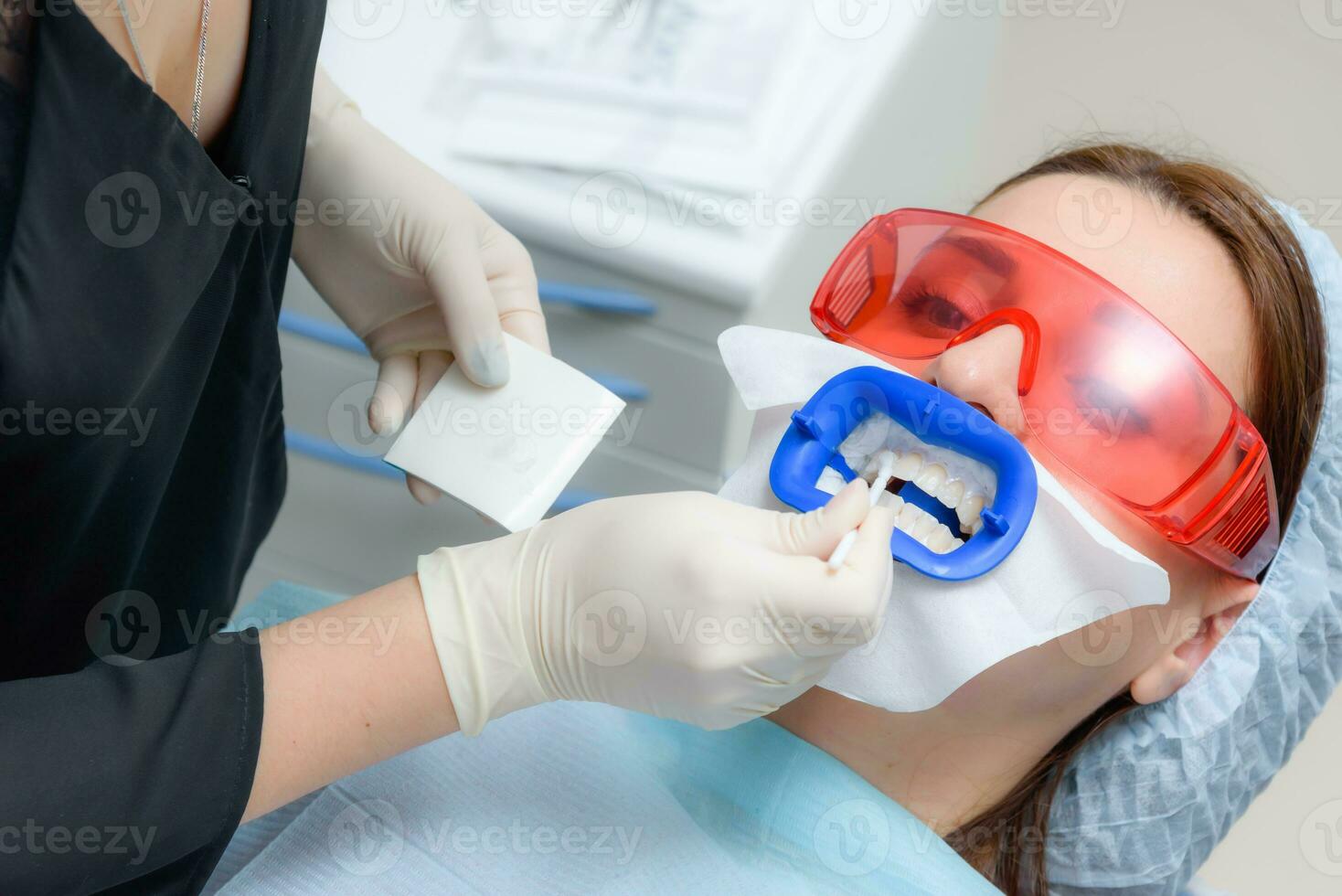 en train de préparer le oral cavité pour blanchiment avec un ultra-violet lampe. fermer photo