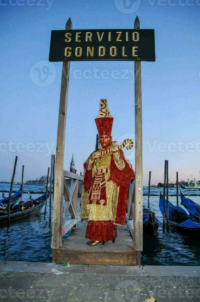 une homme habillé dans une costume des stands dans de face de une signe cette dit servizio gondole photo