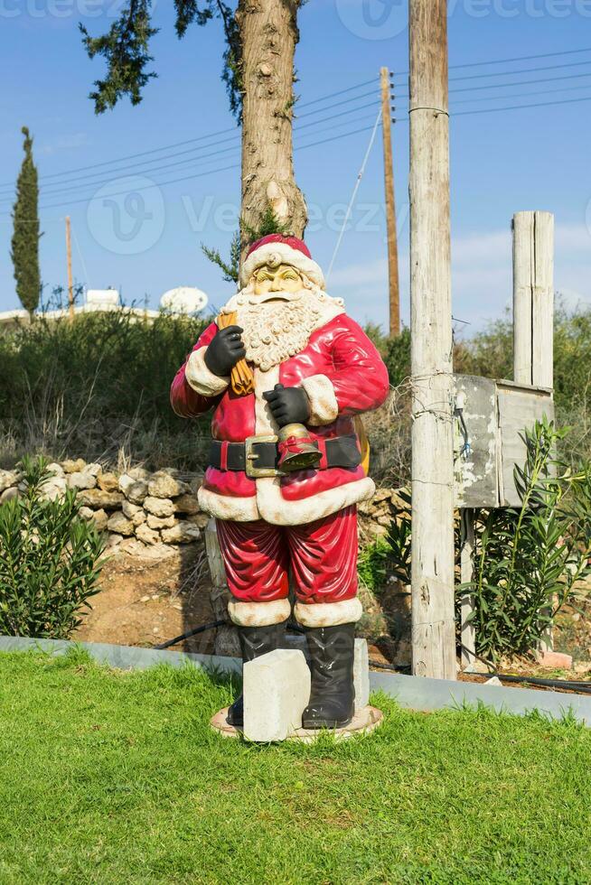 Père Noël claus poupée. Père Noël statue avec Noël décoration sur vert herbe. photo