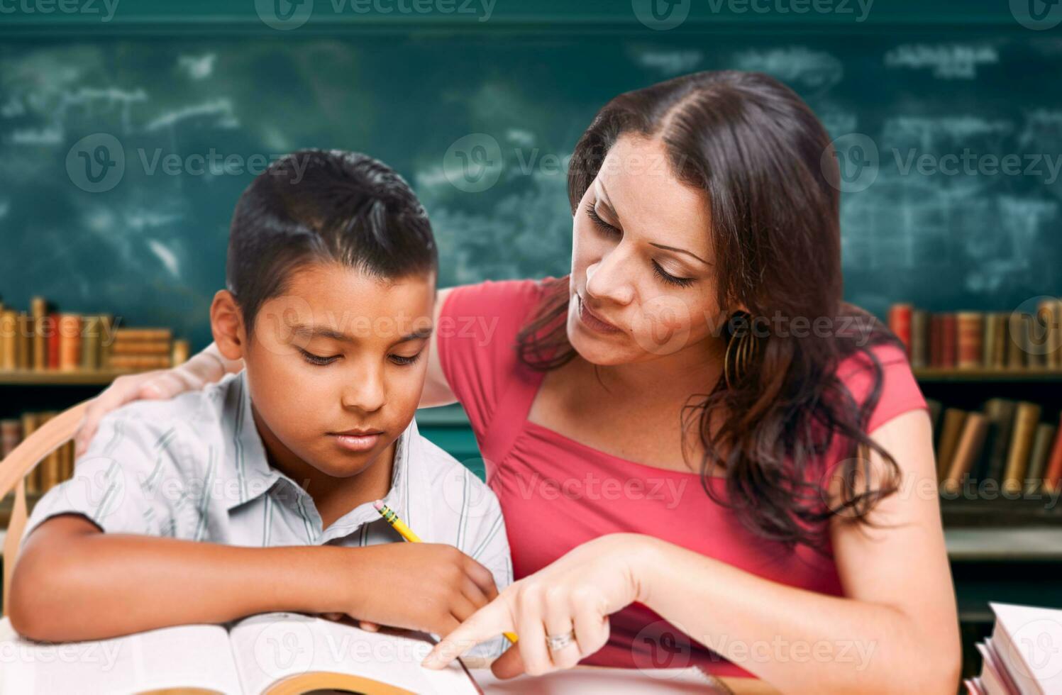 latina école prof tutorat une Jeune hispanique garçon dans le salle de cours bibliothèque photo