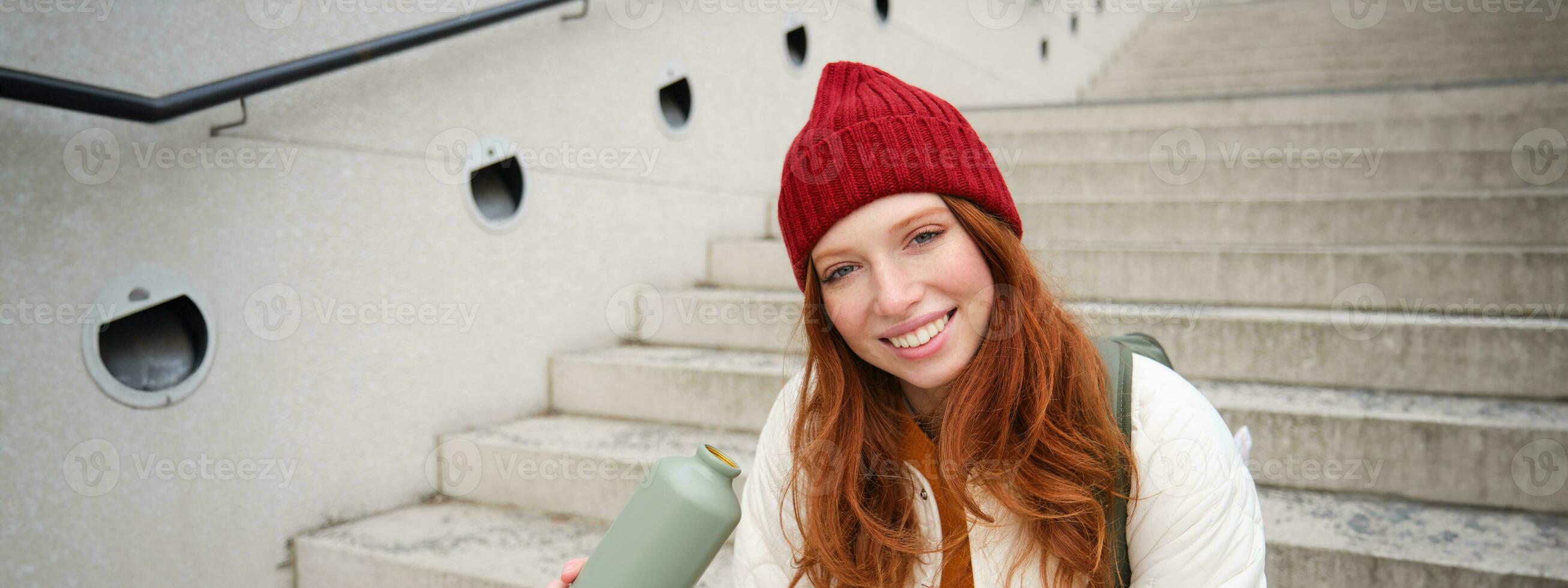 content roux femme, touristique avec thermos, les boissons sa chaud thé, café de Voyage ballon, tests pendant sa en voyageant dans ville et tourisme photo