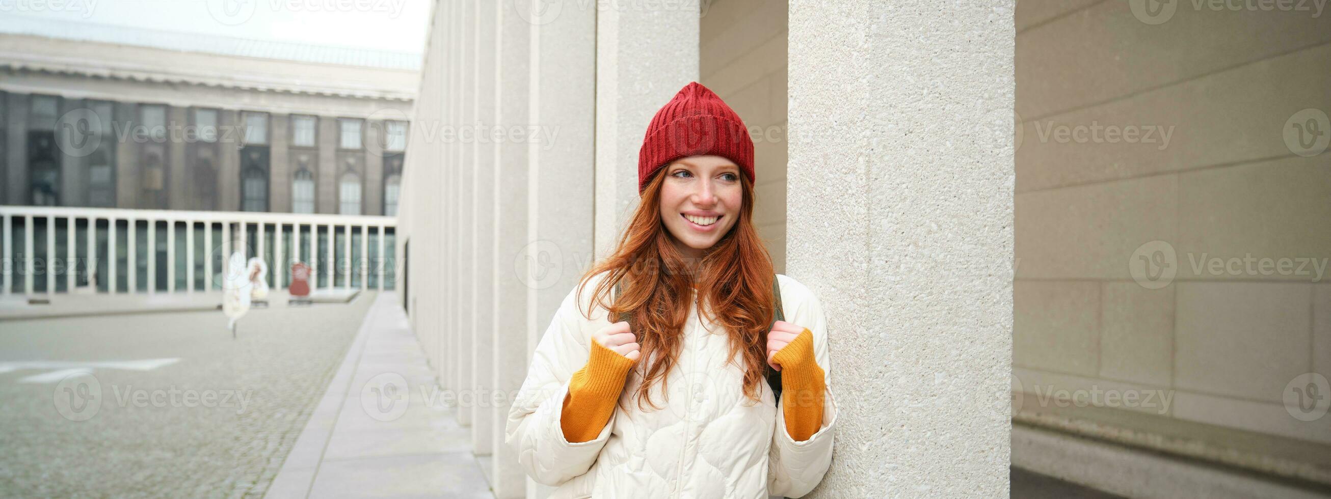 femelle touristique dans rouge chapeau avec sac à dos, touristique, explore historique Repères sur sa voyage autour L'Europe , souriant et posant sur rue photo