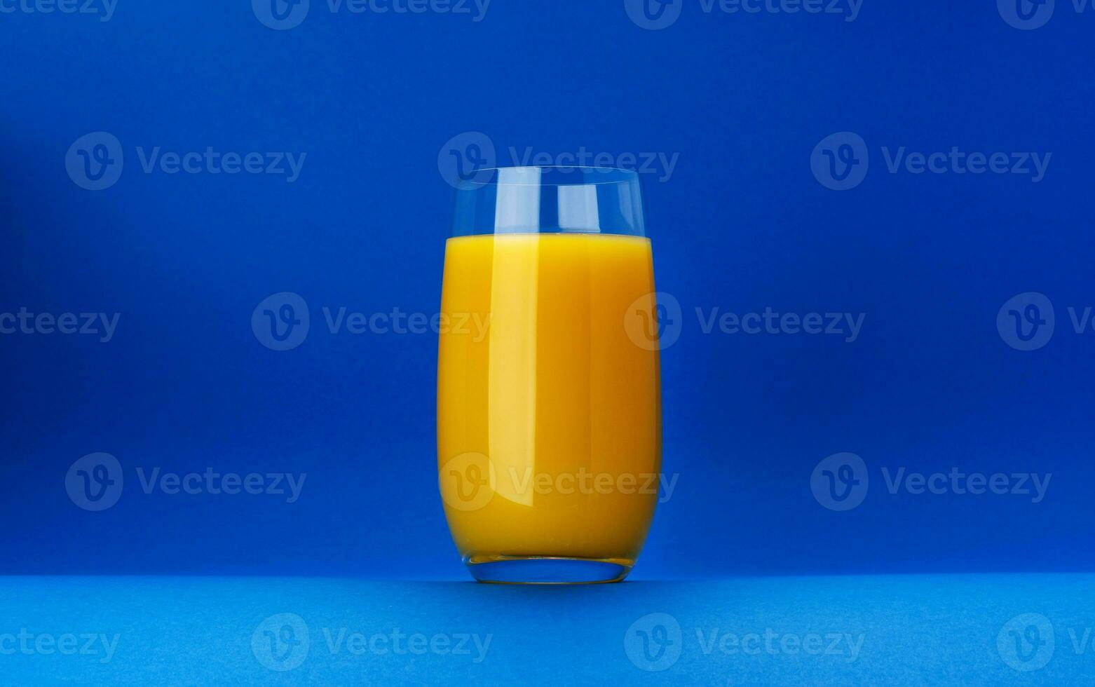 verre de Orange jus isolé sur bleu Contexte avec copie espace photo