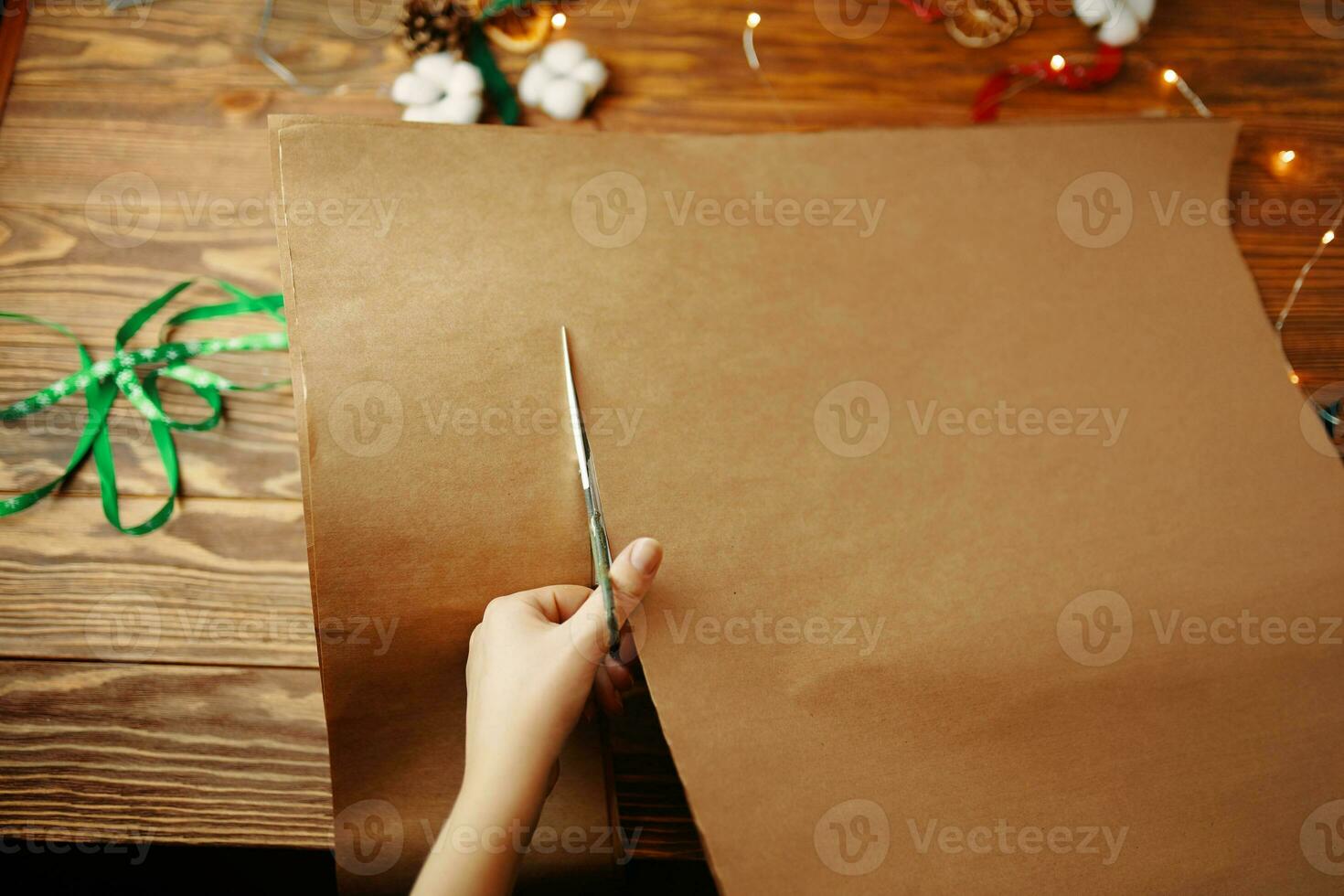 les mains coupent une feuille de papier kraft avec des ciseaux. photo