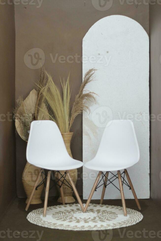 Contexte pour Photos dans le photo studio avec une marron thème et esthétique blanc chaises décoré avec artificiel fleurs