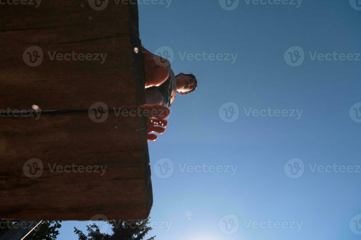 une la personne permanent sur une en bois Plate-forme avec leur pieds dans le air photo