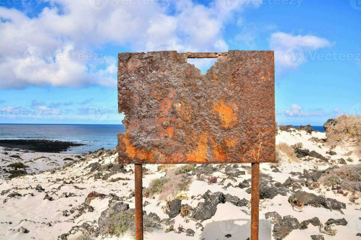 une rouillé signe sur le plage près le océan photo