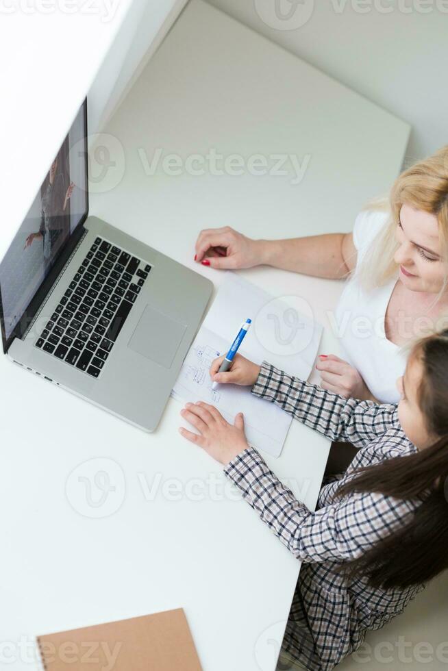 travail de Accueil avec enfant. content fille étreindre mère. Jeune femme et mignonne enfant en utilisant portable. pigiste lieu de travail. femelle entreprise, distance apprentissage. mode de vie famille moment. photo