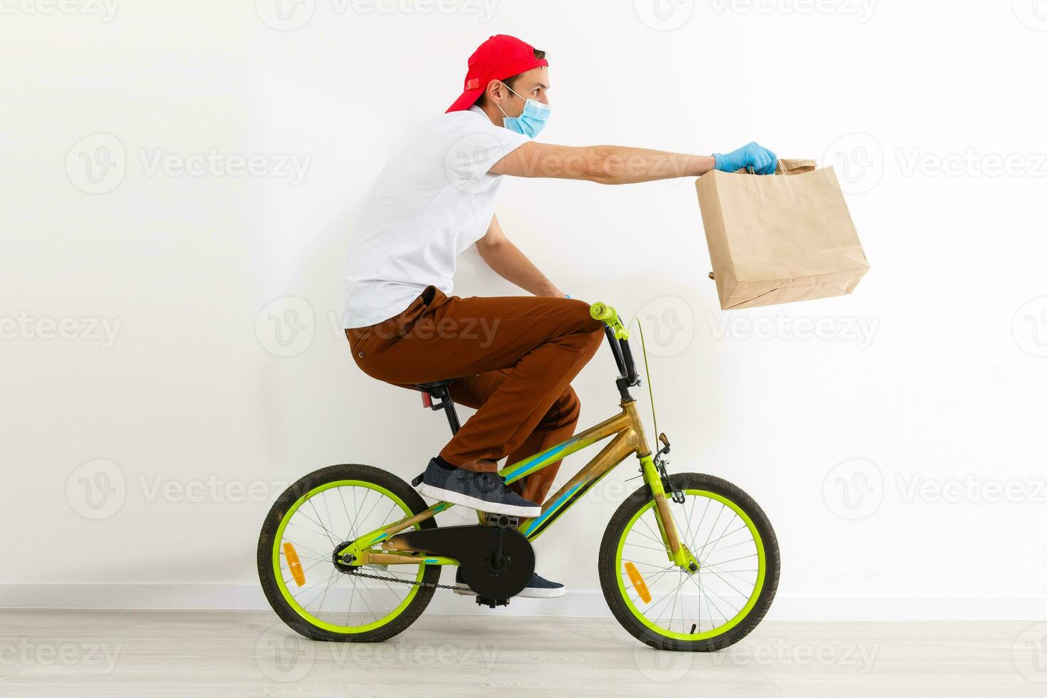une homme dans protecteur masque est livrer nourriture sur une vélo. en ligne achats et Express livraison . quarantaine photo