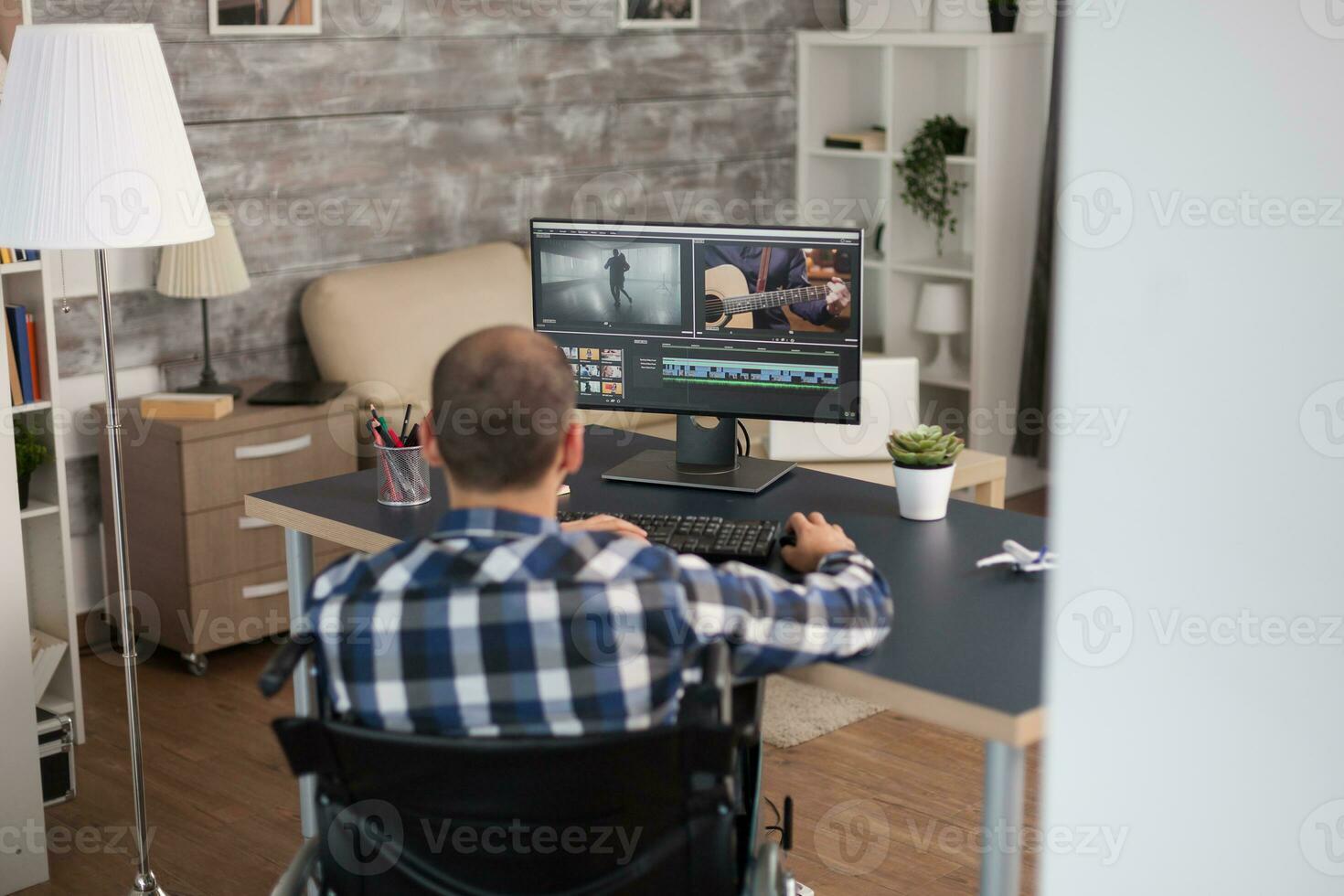 vidéo éditeur travail de Accueil séance dans fauteuil roulant devant le ordinateur. invalide vidéaste Faire le sien affaires en ligne, en utilisant haute technologie, séance dans le sien appartement, travail à distance dans spécial conditions. photo