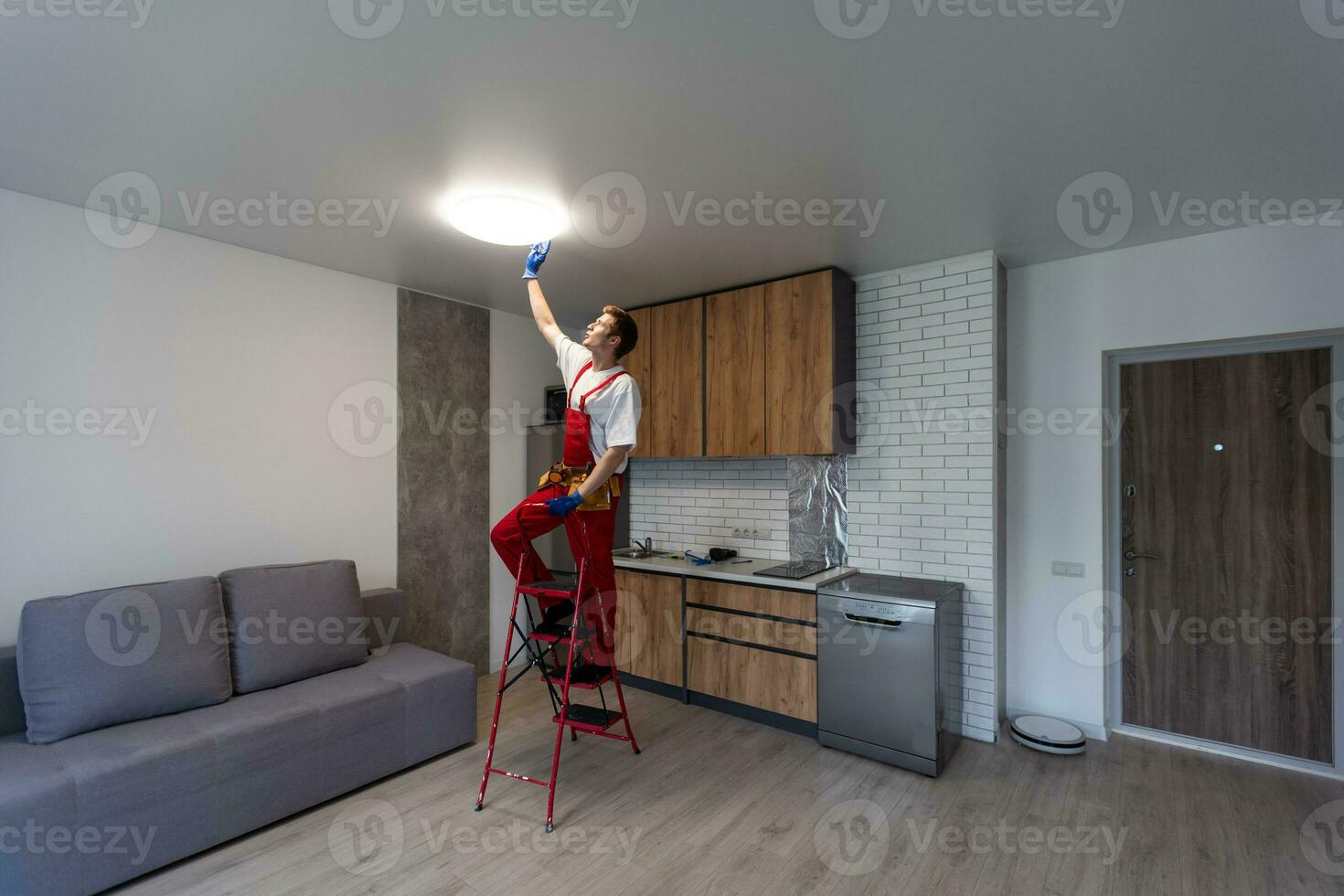 ouvrier installation lampe sur étendue plafond à l'intérieur. photo