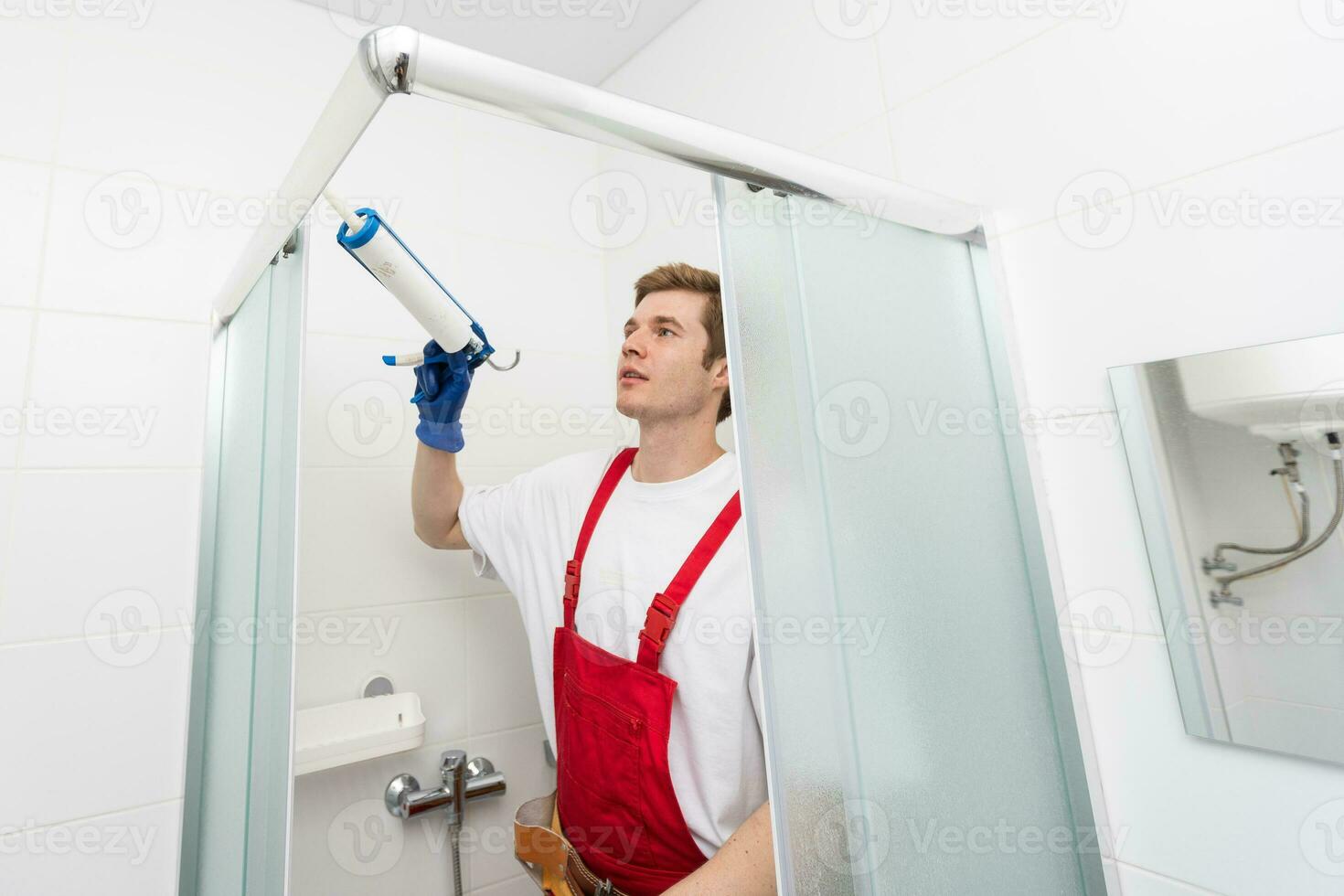 ouvriers sont installation une silicone joint joint sur le verre porte de  le douche enceinte. 35203016 Photo de stock chez Vecteezy
