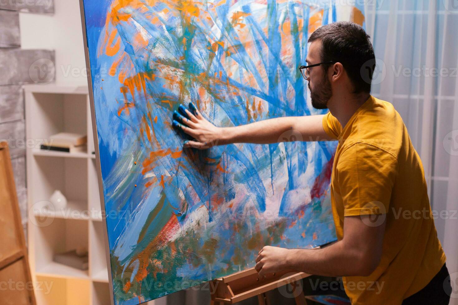 réussi artiste dans studio La peinture avec mains sur toile. moderne ouvrages d'art peindre sur toile, créatif, contemporain et réussi bien art artiste dessin chef-d'oeuvre photo