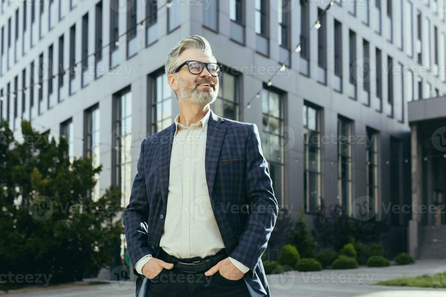 portrait de Sénior réussi investisseur, mature homme d'affaire à l'extérieur Bureau bâtiment dans affaires costume et lunettes, gris aux cheveux banquier souriant et à la recherche loin. photo