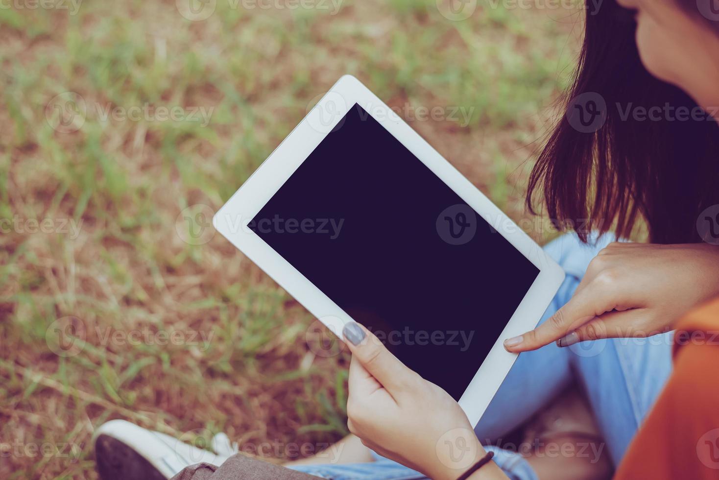 femme asiatique de beauté à l'aide de tablette au parc. concept humain et technologique. thème loisirs et activités de plein air photo