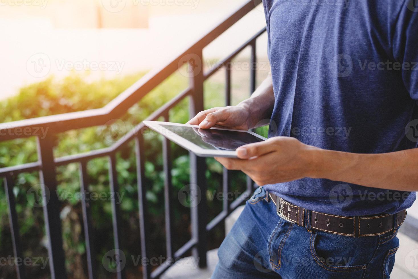 gros plan de la main de l'homme à l'aide d'une tablette en marchant à l'extérieur. concept de technologie et de modes de vie. thème des travailleurs et des gadgets photo