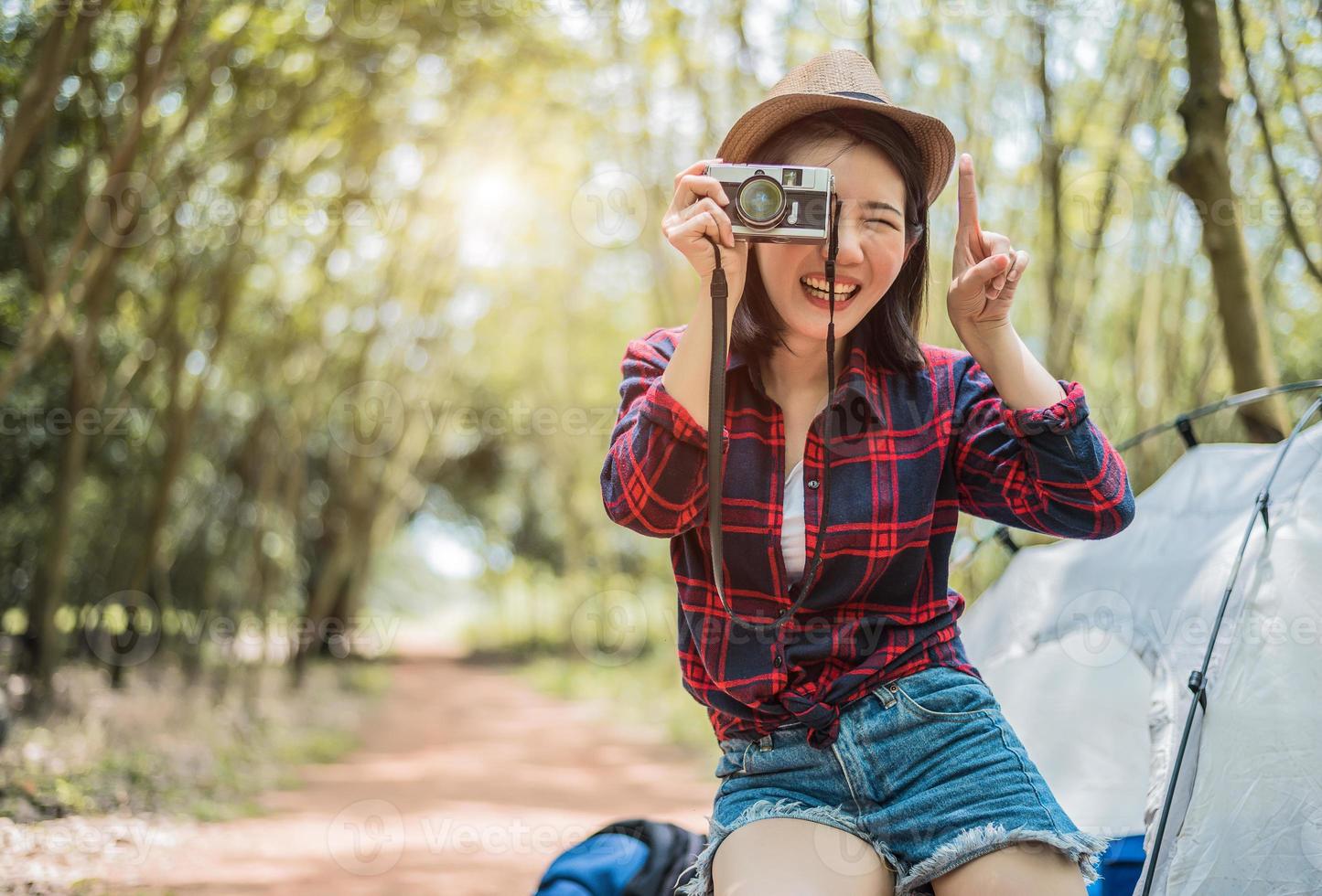 voyageur de beauté asiatique prenant une photo par cemera numérique lors d'une randonnée en camping. concept d'activité d'aventure et de loisirs. vie heureuse et thème de la technologie. thème fille solo