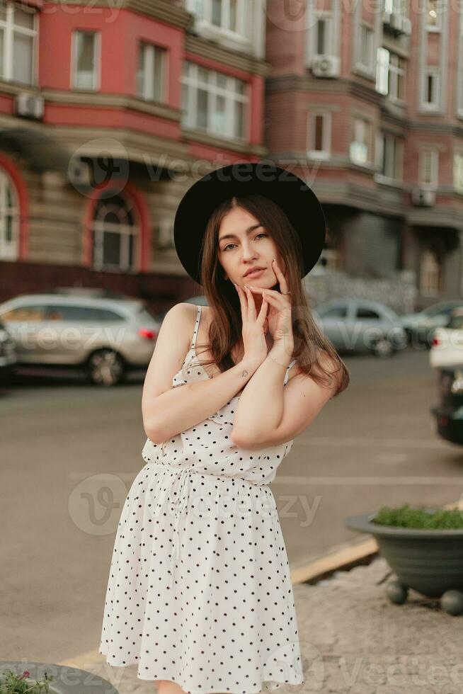 une Jeune adolescent fille dans une blanc robe et chapeau photo