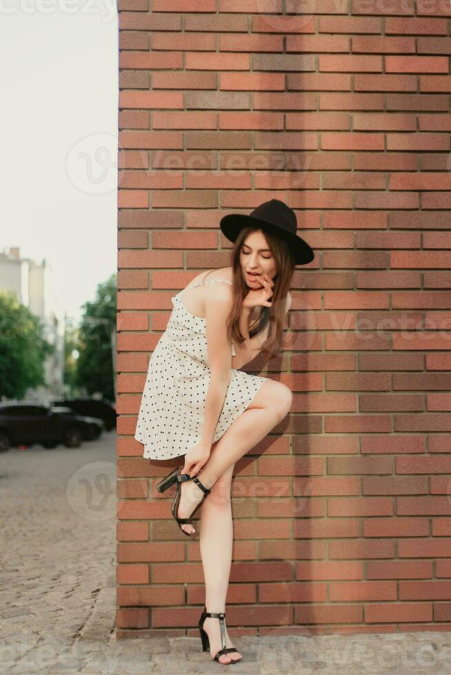 une Jeune adolescent fille dans une blanc robe et chapeau photo