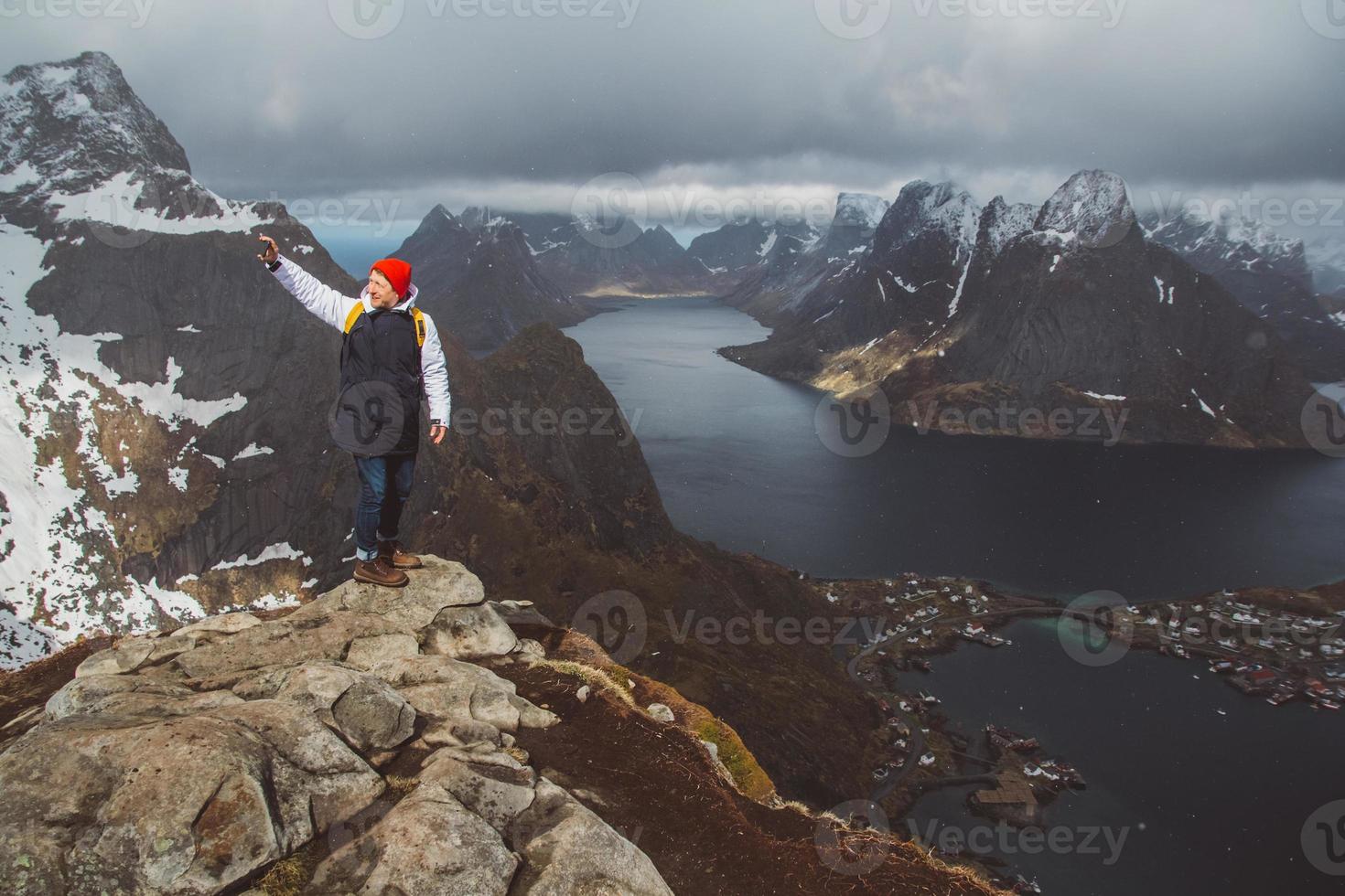 Homme voyageur prenant une photo avec un smartphone en randonnée sur la crête de la montagne en Norvège