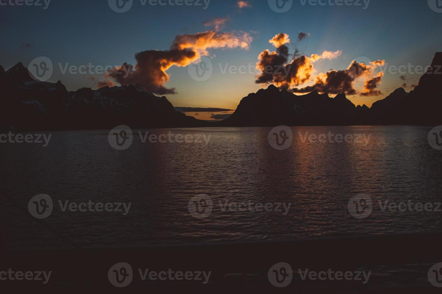 coucher de soleil sur les montagnes au bord de la mer photo