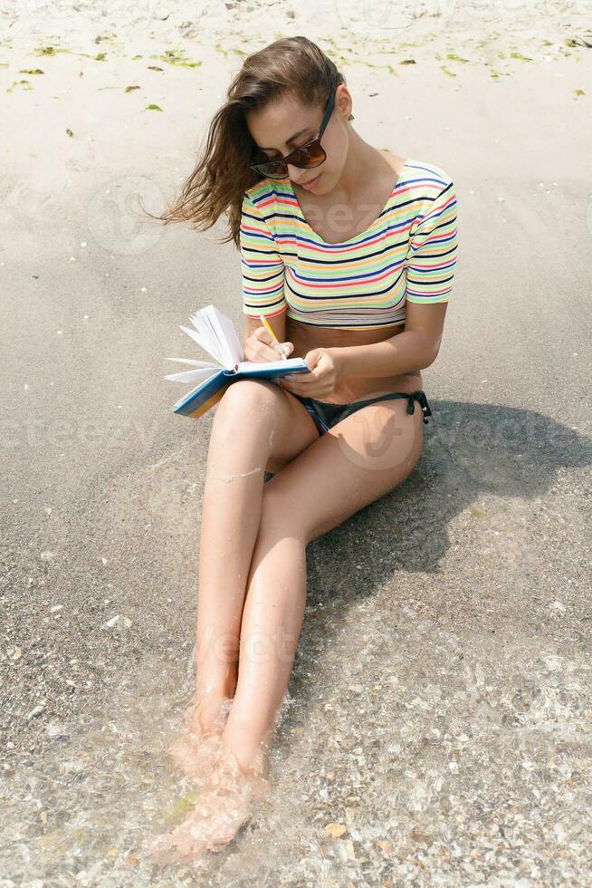 femelle fait du Remarques et séance sur le plage photo