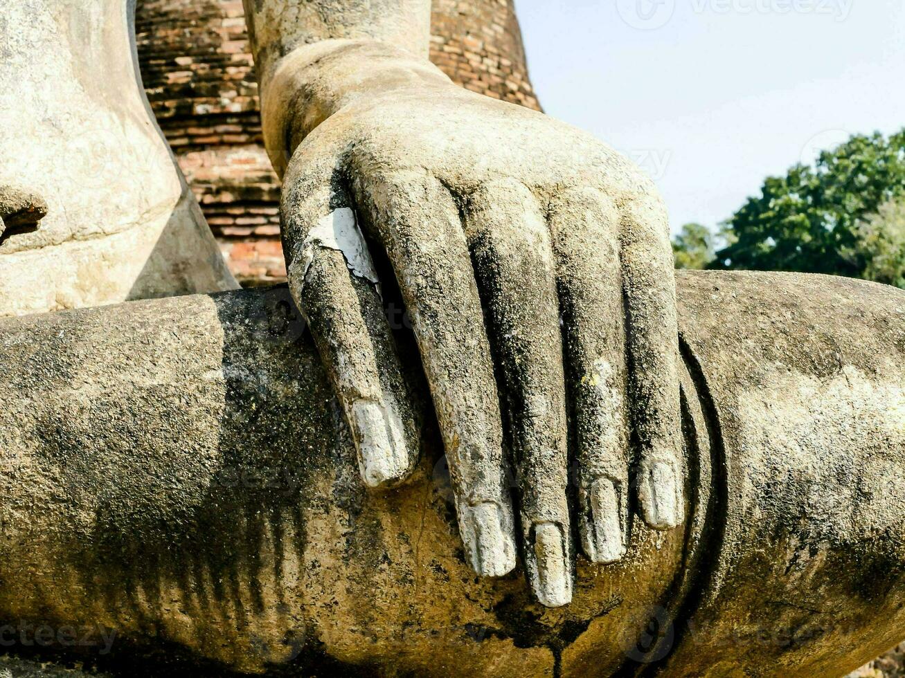 une proche en haut de une Bouddha statue avec ses mains photo