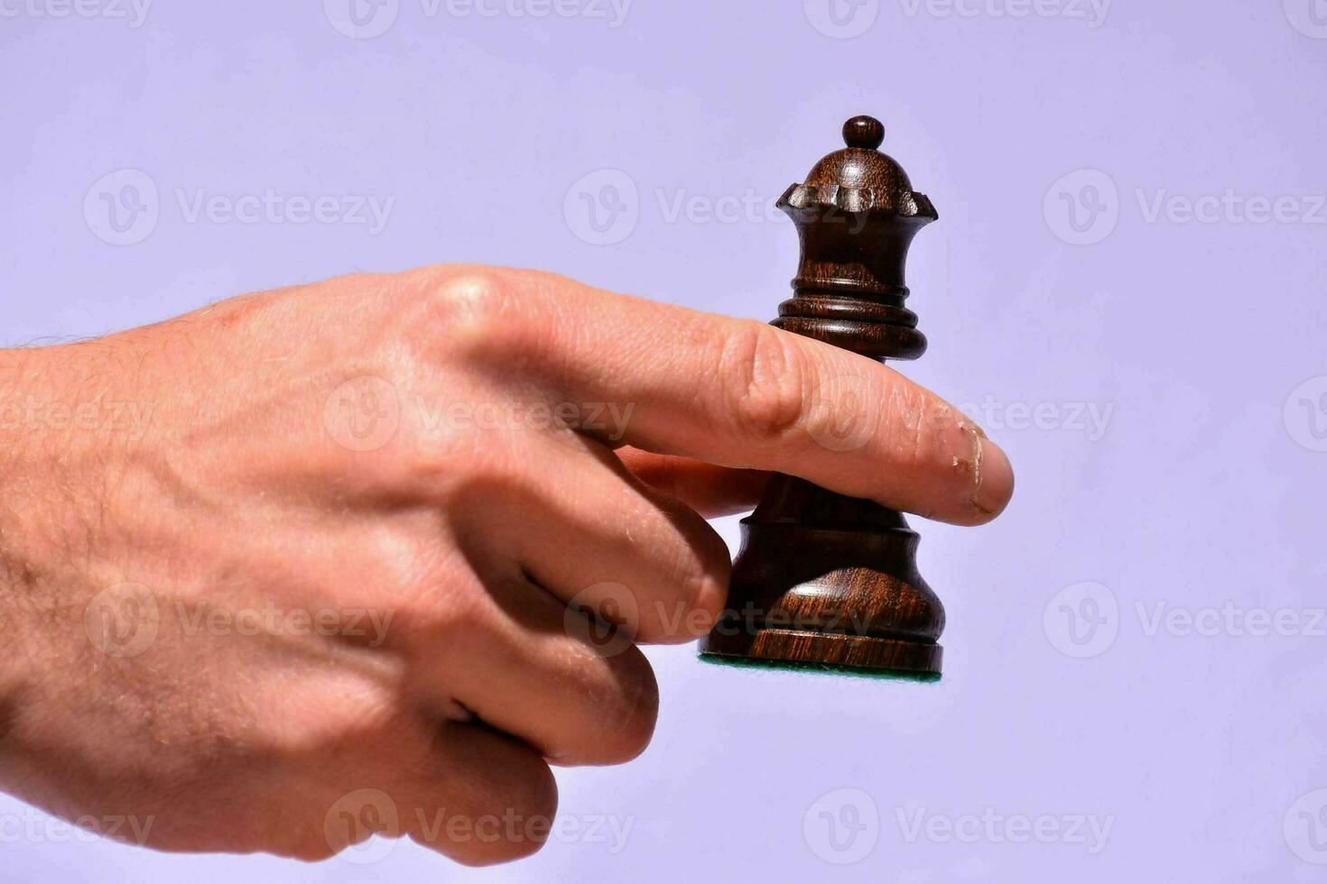une main en portant une échecs pièce sur une blanc Contexte photo