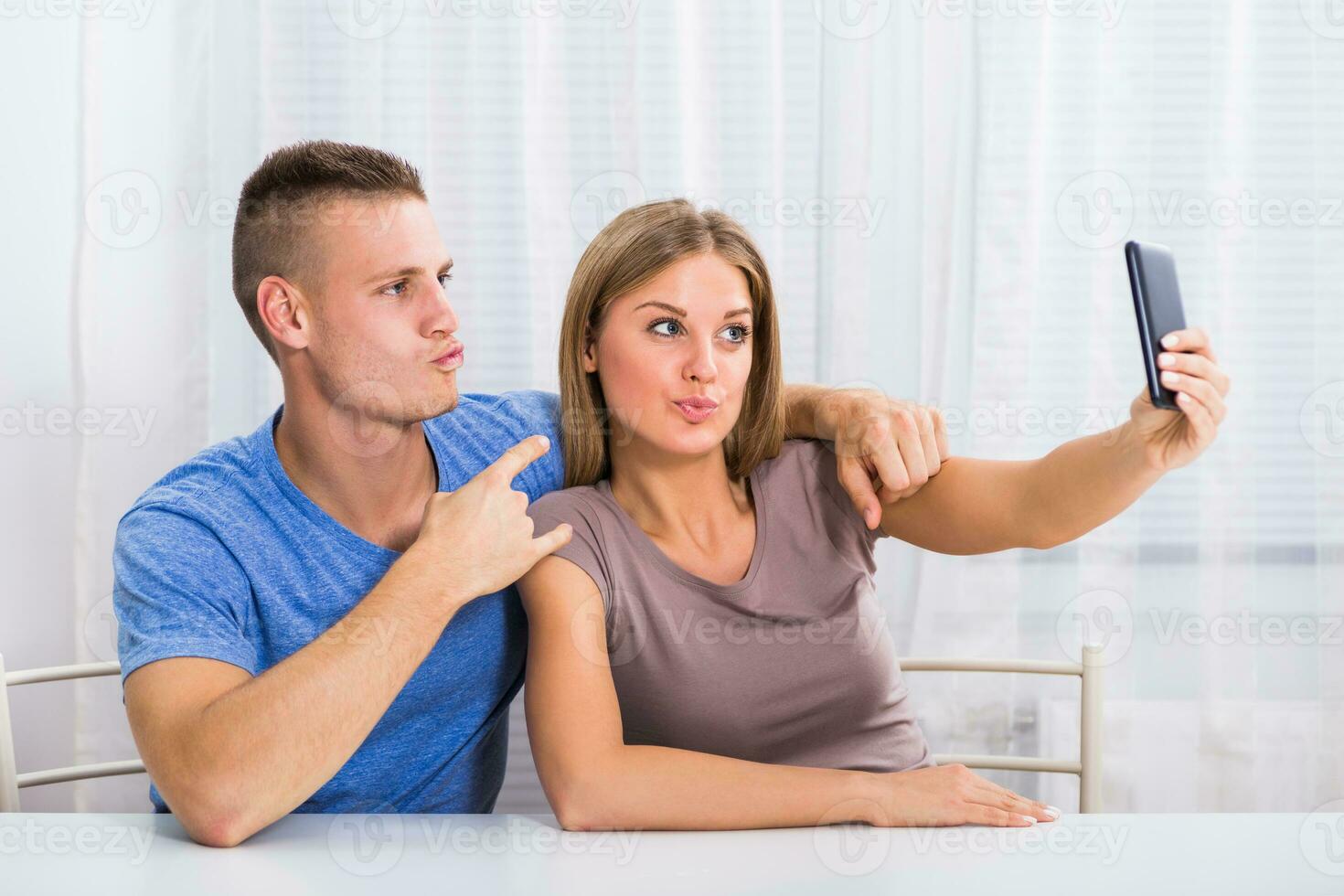 Jeune content couple séance à le table et prise selfie. photo