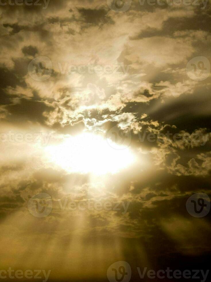 rayons de soleil brillant par des nuages dans le ciel photo