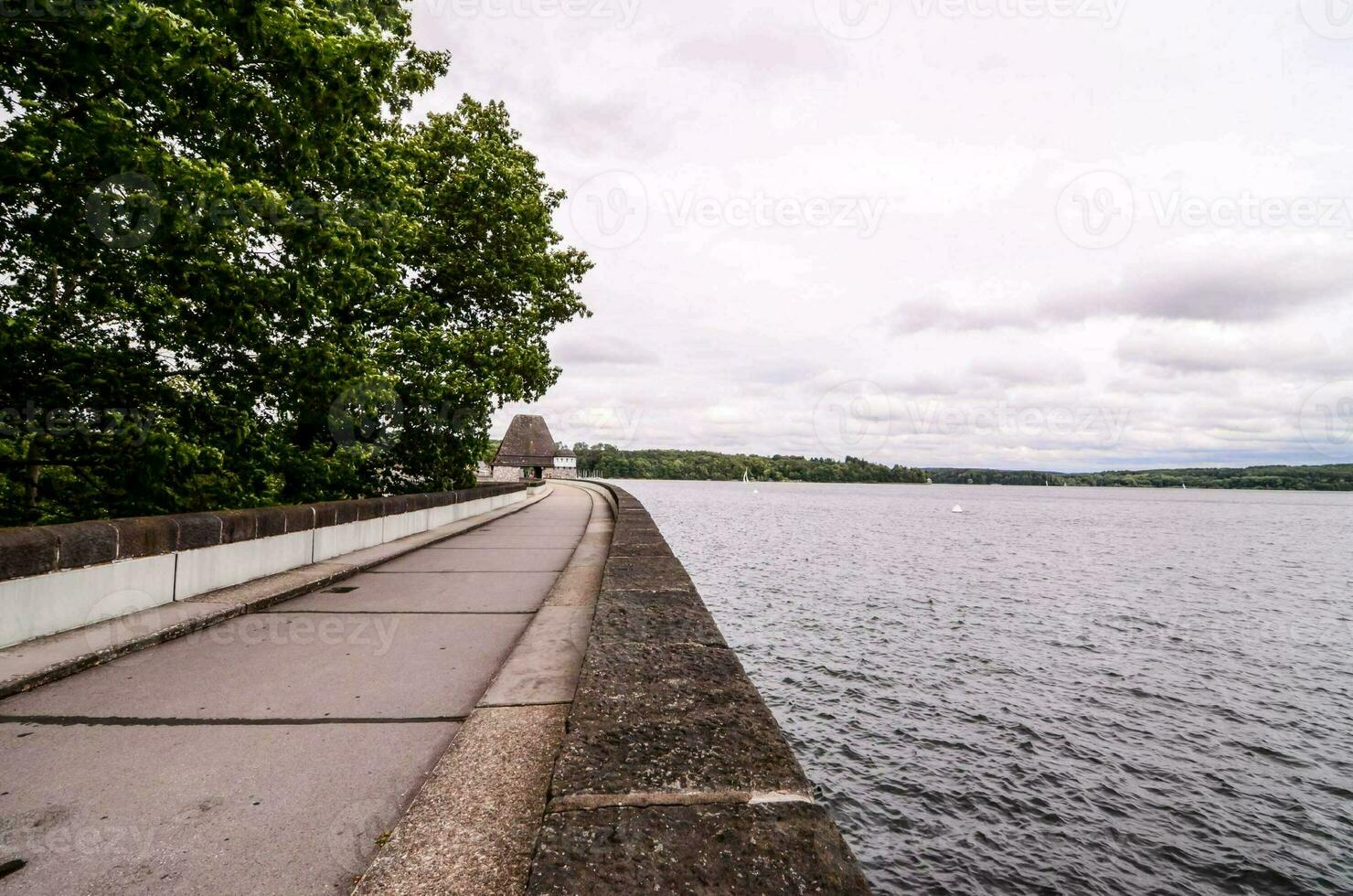 une longue passerelle le long de le côté de une Lac photo